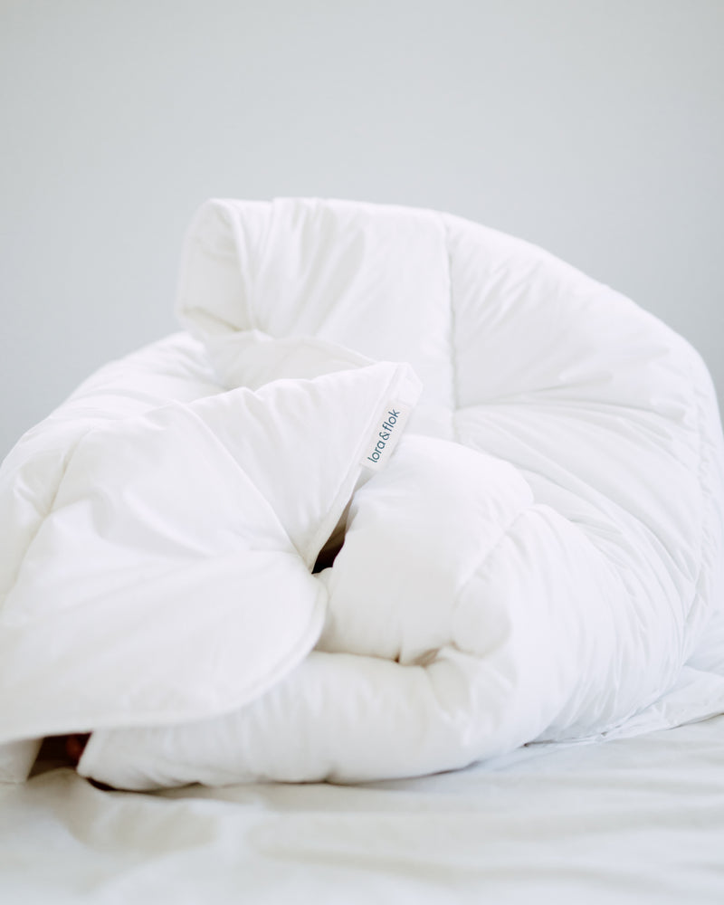 Lora & Flok Lofty duvet inner looking cozy on an unmade bed.