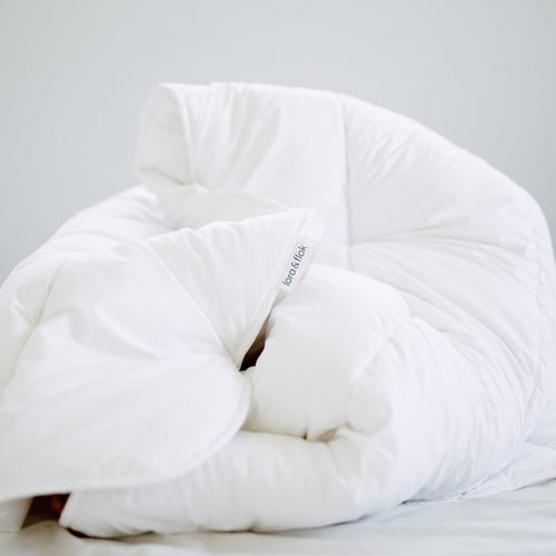 Lora & Flok Lofty duvet inner looking cozy on an unmade bed. 